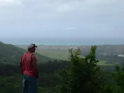 Rob Tatum standing on a hillside overlook, gazing out at a misty valley and distant coastline.