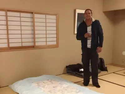 Rob Tatum standing in a traditional Japanese-style room with tatami mats and a floor futon.