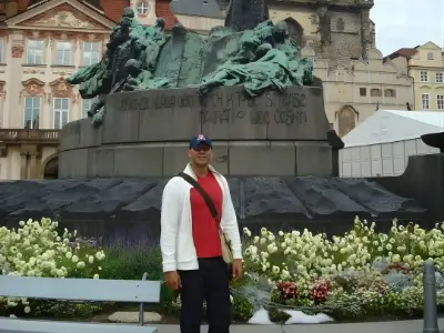 Rob Tatum standing in front of a large historic monument with flowers in the foreground.